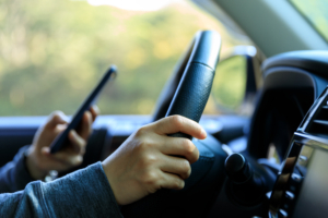 driver of a car looking at his phone
